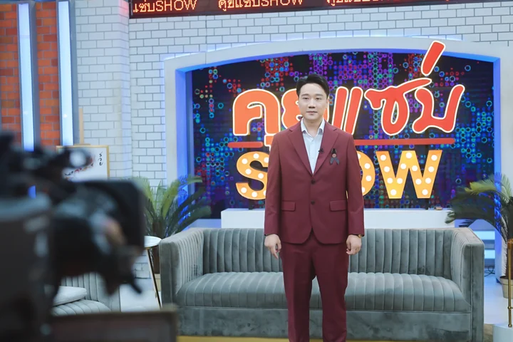 สมเจตน์ในชุดสูทแดงยืนหน้าฉากรายการคุยแซ่บ SHOW